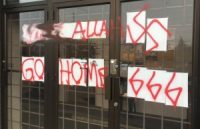 [A photograph of the front of the Ottawa Muslim Association mosque, showing crude graffiti spraypainted in red. The graffiti is 'FUCK ALLAH', then a swastika, then 'GO HOME', then '666'.]