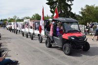 [Photo of a parade float consisting of a golf-cart pulling a train of large posters displaying anti-abortion messages.]